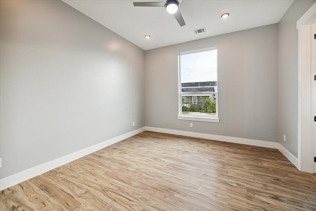 empty room with baseboards, visible vents, and wood finished floors