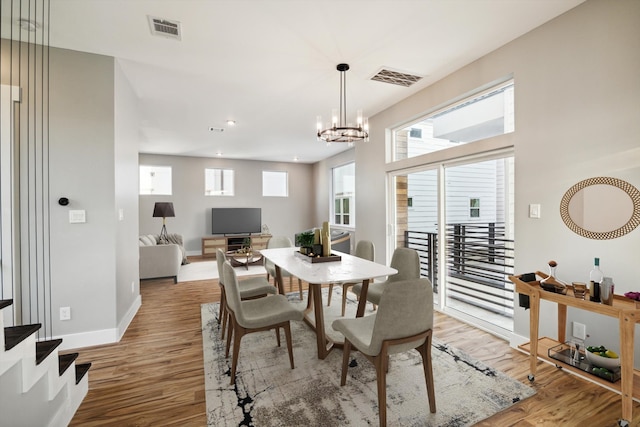dining area with a wealth of natural light, light wood-style flooring, and visible vents