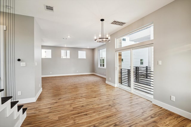 spare room featuring a healthy amount of sunlight, light wood-style flooring, and visible vents