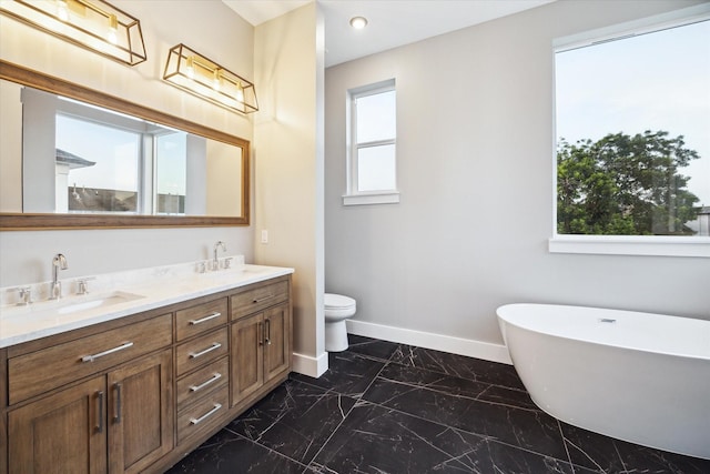 full bath featuring baseboards, marble finish floor, toilet, a sink, and double vanity