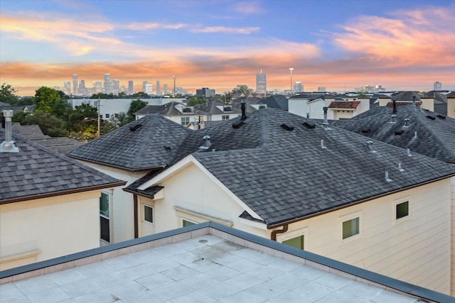 details featuring gutters, a downspout, a city view, stucco siding, and roof with shingles