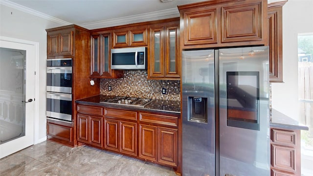 kitchen with glass insert cabinets, brown cabinetry, crown molding, backsplash, and appliances with stainless steel finishes
