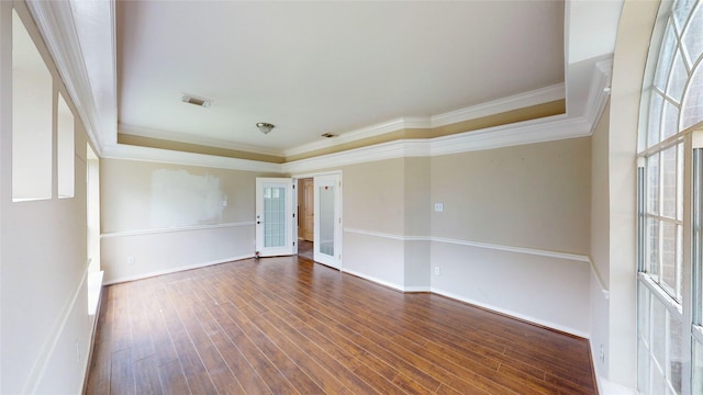 empty room with french doors, baseboards, visible vents, crown molding, and wood finished floors