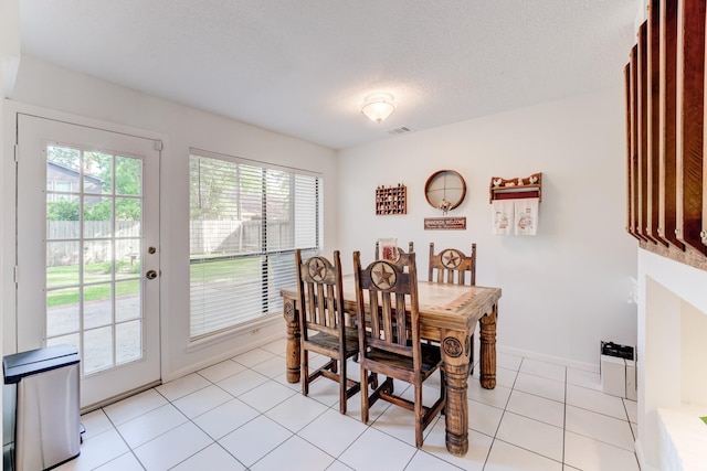 dining room featuring baseboards, light tile patterned floors, and visible vents