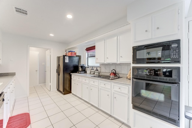 kitchen featuring black appliances, visible vents, white cabinetry, decorative backsplash, and light countertops