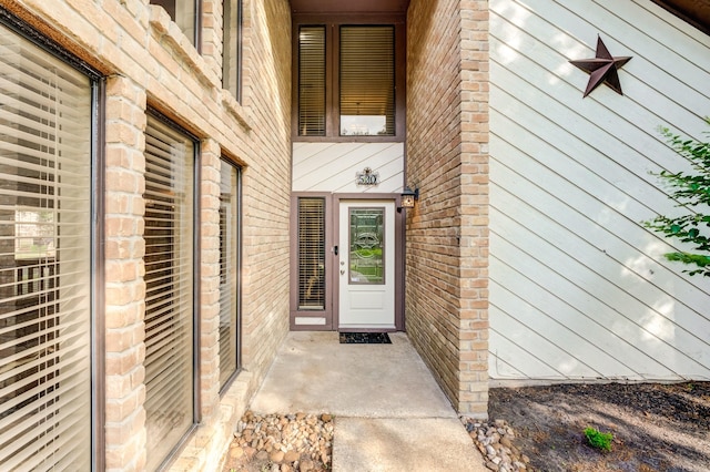 doorway to property featuring brick siding