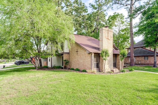 mid-century modern home with brick siding, a front lawn, and a chimney