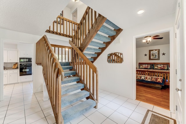 stairs featuring tile patterned floors, visible vents, and ceiling fan