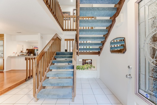 staircase with visible vents, tile patterned flooring, and baseboards