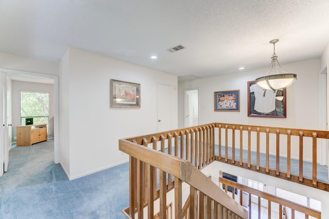 corridor with an upstairs landing, recessed lighting, visible vents, carpet flooring, and baseboards
