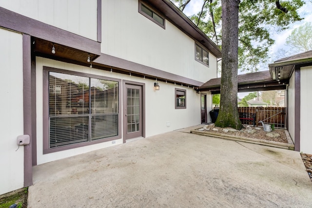 rear view of house with fence, a patio, and stucco siding