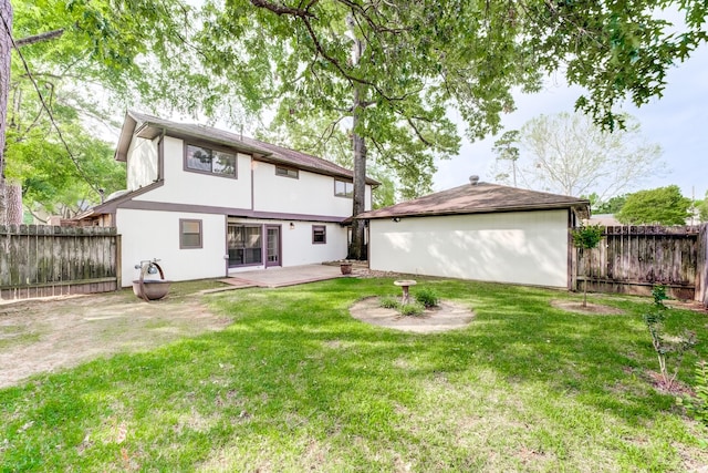 rear view of house featuring a yard, stucco siding, a fenced backyard, and a patio