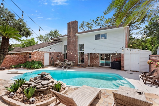 view of pool featuring a patio area, a diving board, and fence