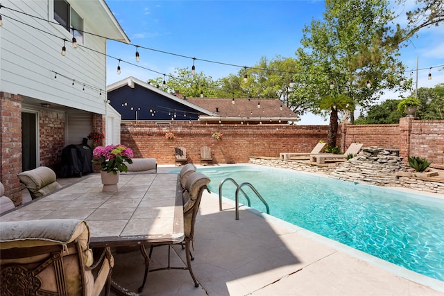 view of swimming pool with a fenced backyard, a patio area, and a grill