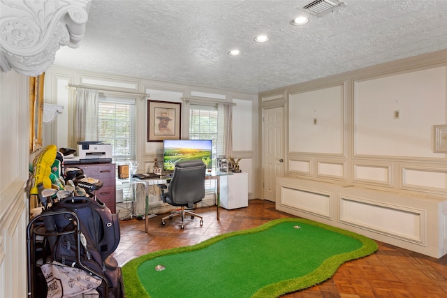 office space featuring a decorative wall, a textured ceiling, and crown molding