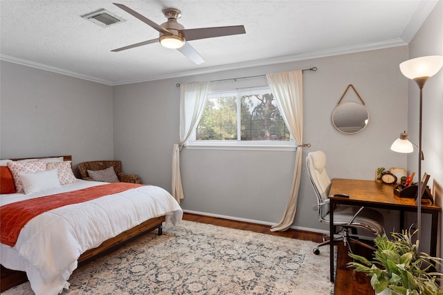 bedroom featuring wood finished floors, baseboards, ornamental molding, a ceiling fan, and an office area