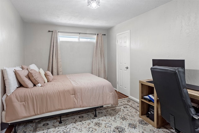 bedroom featuring a textured ceiling and an office area