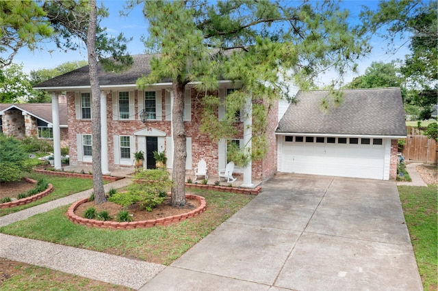 greek revival house featuring brick siding, concrete driveway, fence, a shingled roof, and a garage