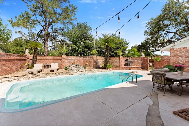 view of pool with a fenced backyard and a patio