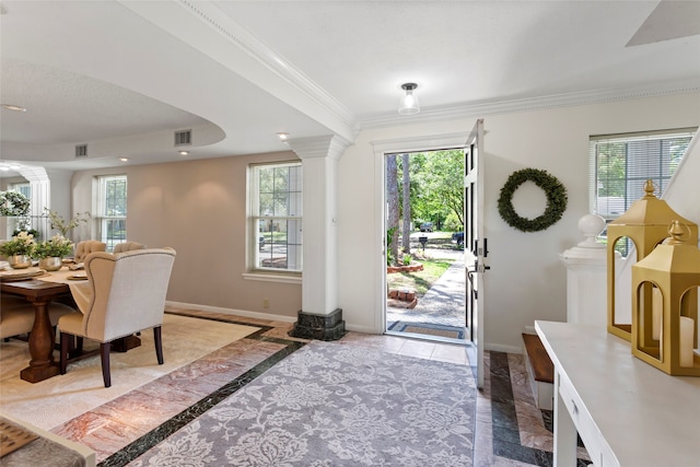 foyer entrance featuring ornate columns, inlaid floor details, baseboards, ornamental molding, and marble tiled floors