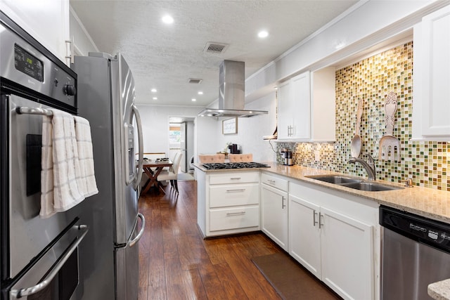 kitchen with appliances with stainless steel finishes, island exhaust hood, a textured ceiling, a peninsula, and dark wood-type flooring