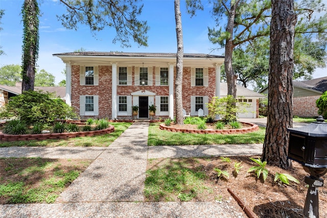 neoclassical home featuring brick siding