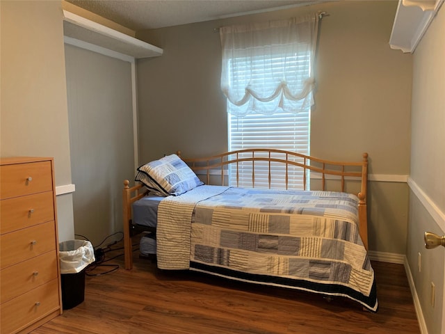 bedroom with baseboards and wood finished floors
