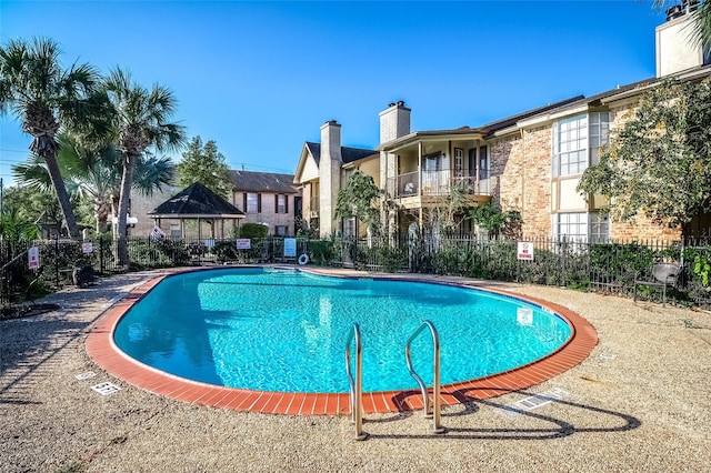 pool with a gazebo and fence