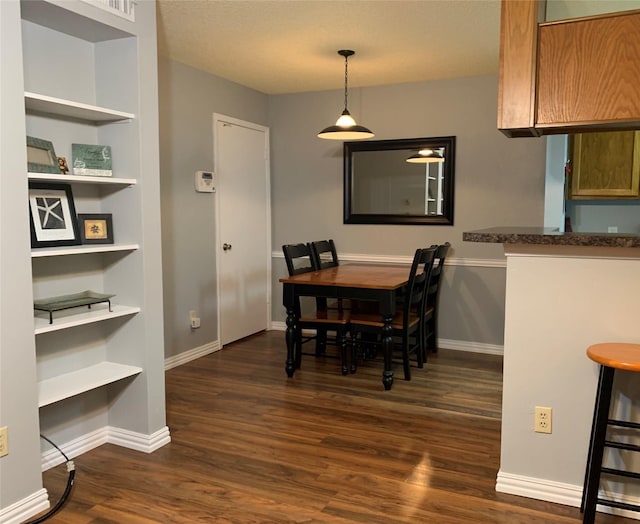 dining space featuring baseboards and dark wood-type flooring