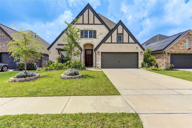 20447 Avelignese Way, Tomball, TX 77377 - tudor-style house featuring driveway, brick siding, a garage, stone siding, and a front yard