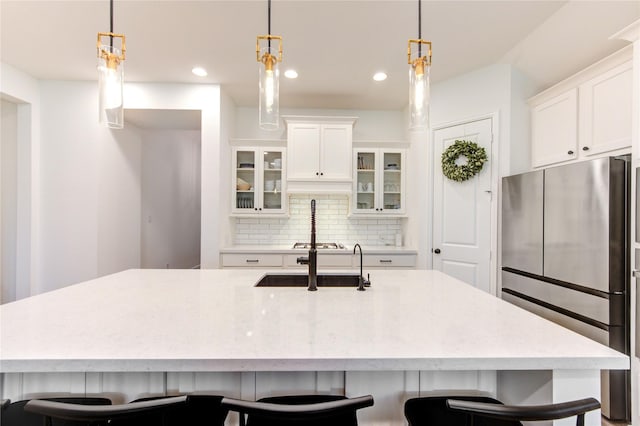 20447 Avelignese Way, Tomball, TX 77377 - kitchen featuring a kitchen breakfast bar, white cabinetry, backsplash, glass insert cabinets, and appliances with stainless steel finishes