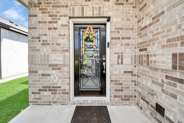 entrance to property featuring brick siding