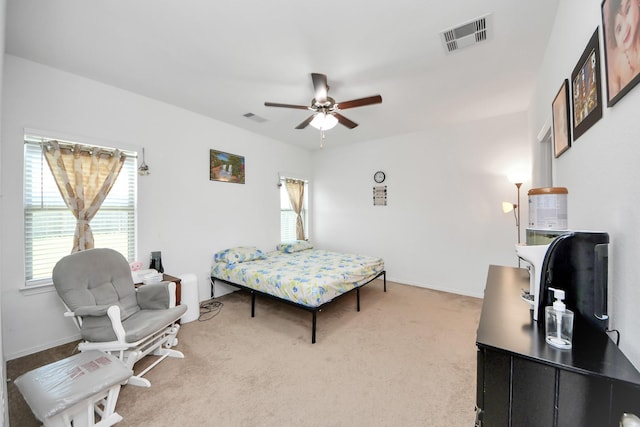 bedroom featuring a ceiling fan, baseboards, visible vents, and light colored carpet