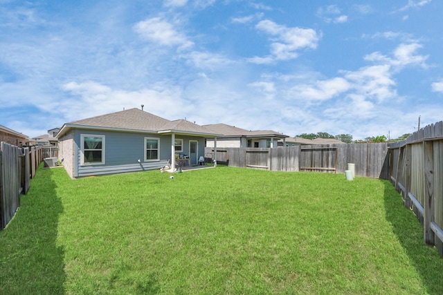 back of house featuring a yard and a fenced backyard