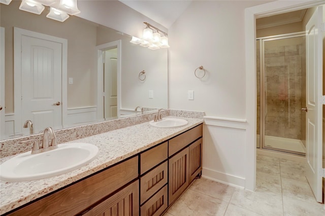 bathroom with double vanity, tile patterned flooring, a stall shower, and a sink