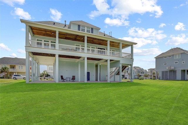 back of house featuring a lawn, a patio area, stairway, and a wooden deck