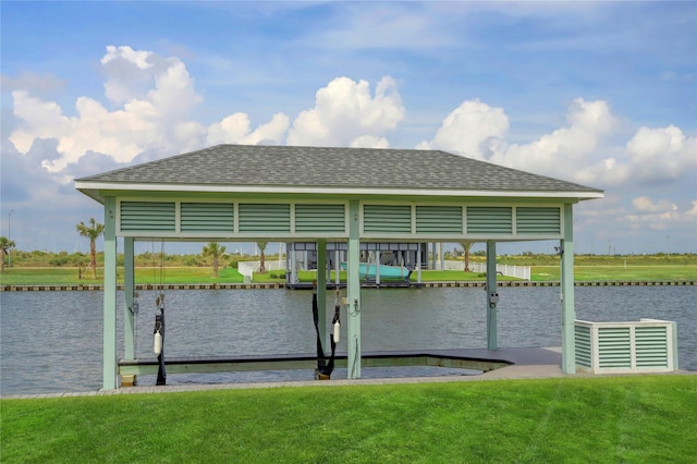dock area featuring boat lift, a yard, and a water view