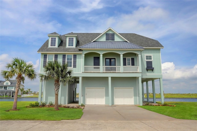 20 Hawkeye, Hitchcock, TX 77563 - beach home with an attached garage, a front lawn, a water view, a balcony, and a shingled roof