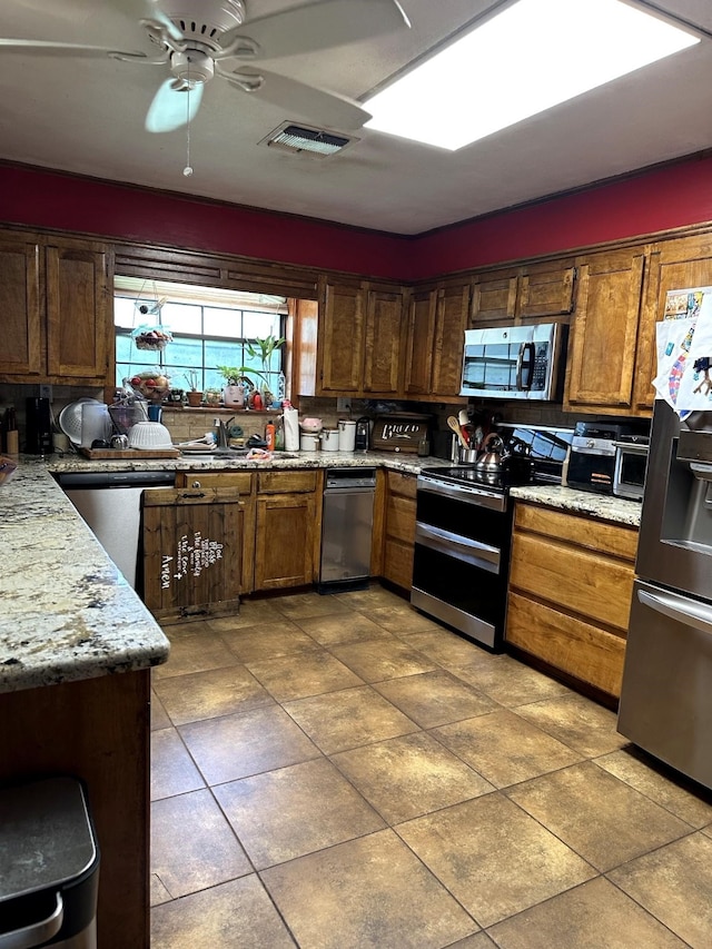 kitchen featuring light tile patterned floors, a ceiling fan, a sink, visible vents, and appliances with stainless steel finishes