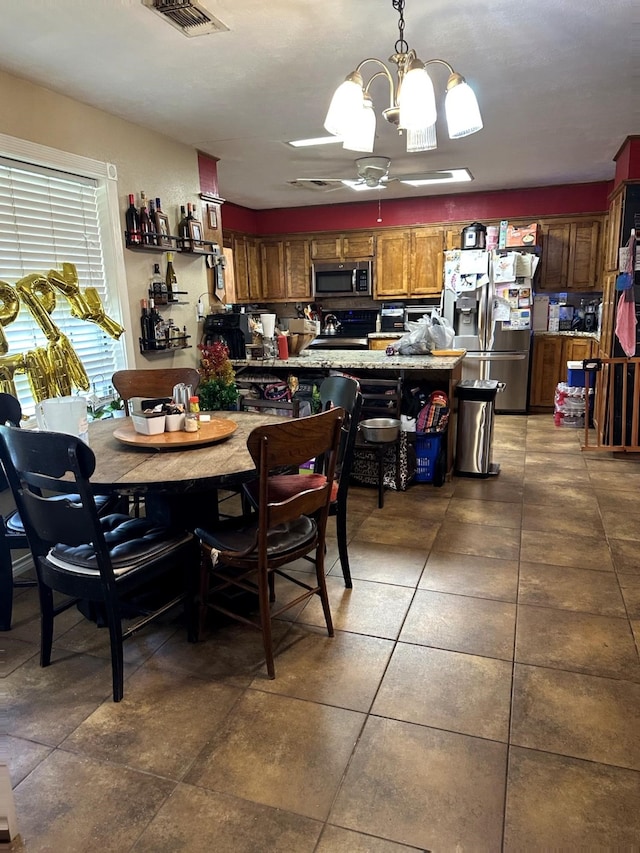 dining area featuring an inviting chandelier, visible vents, and dark tile patterned floors