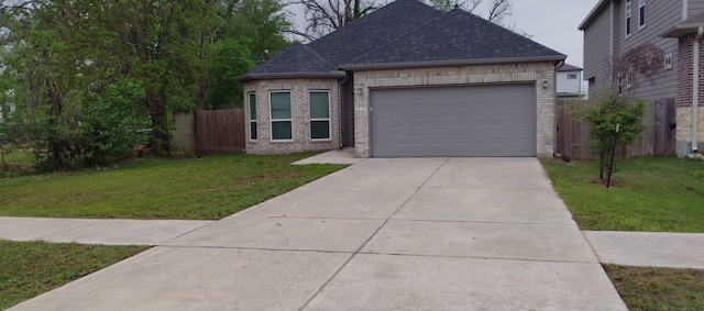 ranch-style home featuring an attached garage, fence, concrete driveway, a front yard, and brick siding