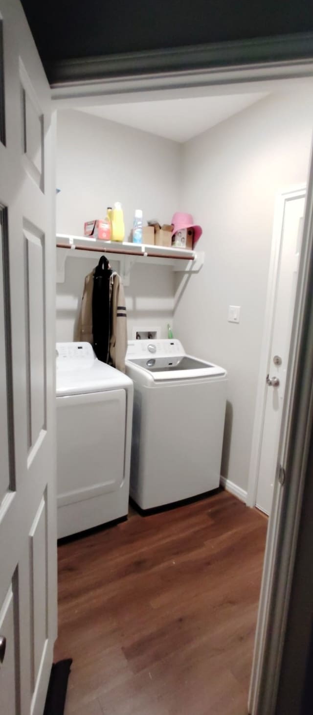 washroom featuring wood finished floors, baseboards, and washer and dryer