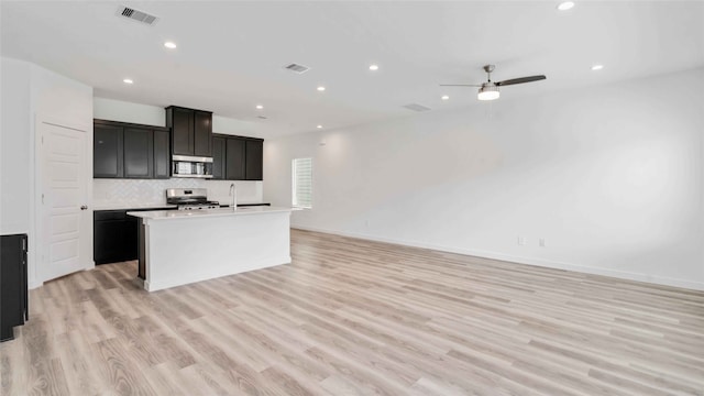 kitchen with stainless steel appliances, visible vents, recessed lighting, decorative backsplash, and open floor plan