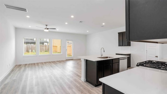 kitchen featuring a sink, open floor plan, a kitchen island with sink, visible vents, and light countertops