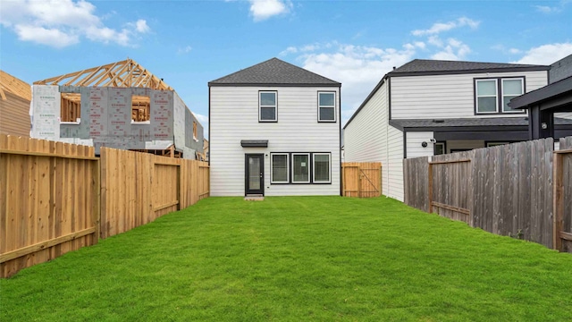back of property featuring a fenced backyard and a yard