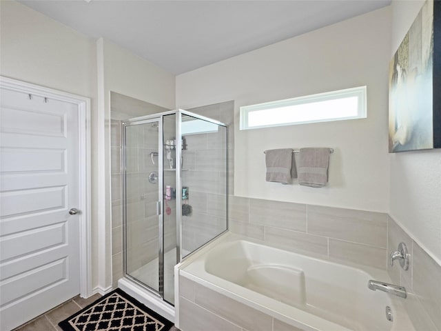 bathroom with a shower stall and a bath