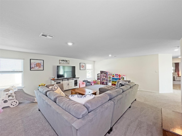 carpeted living room featuring visible vents, baseboards, and recessed lighting