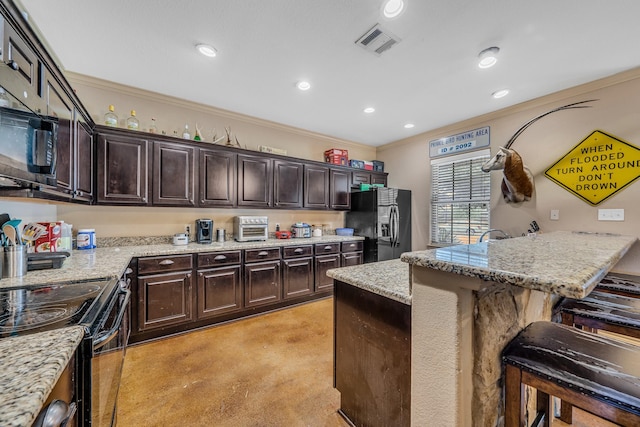 3338 Cullen Trl, College Station, TX 77845 - kitchen featuring a breakfast bar, black appliances, visible vents, crown molding, and dark brown cabinetry