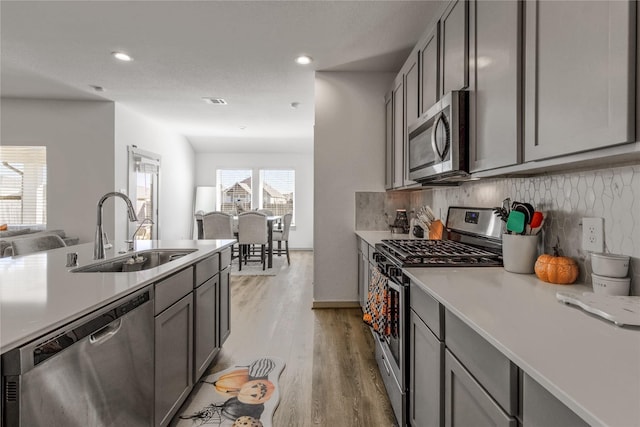 13938 Red River Dr, Baytown, TX 77523 - kitchen featuring gray cabinetry, light countertops, stainless steel appliances, and a sink