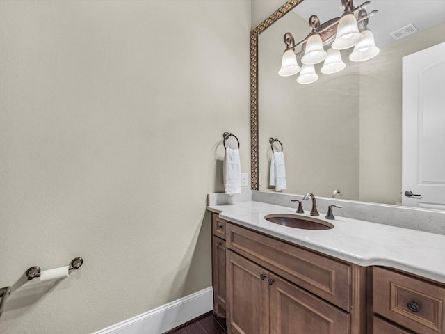 bathroom featuring baseboards, vanity, and visible vents